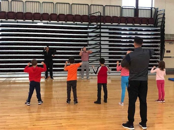 体育学生s teaching elementary school students in gym 