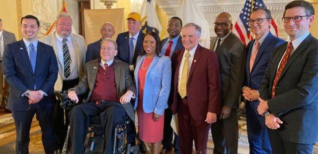 A large group of state leaders, including RIC President Warner, Gov. McKee and former Congressman James Langevin gather in the Governor's State Room at the RI State House.