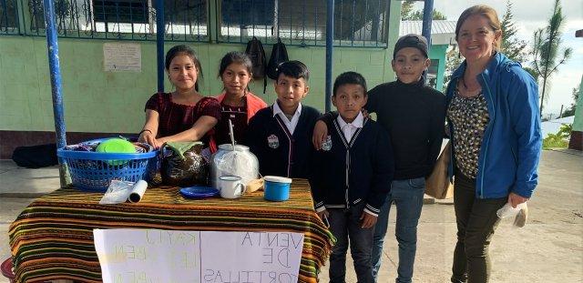 Erin Papa stands beside children selling tortillas