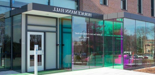 Exterior photo of the front entrance of Horace Mann Hall, showing the quote from Alan Shawn Feinstein that reads, "To Better One Life is to Better the World"